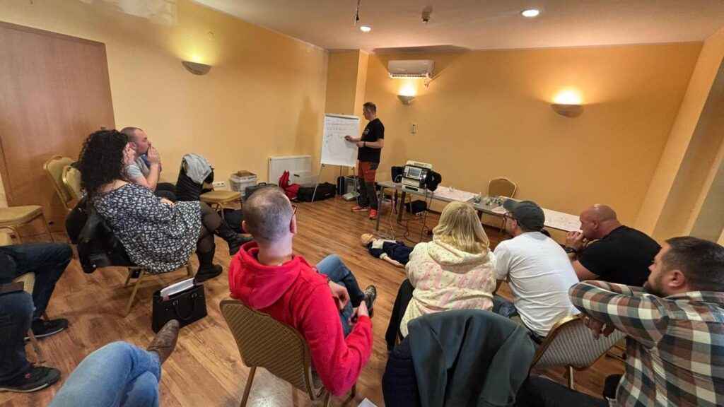 zdjęcie ze szkolenia z zabiegów ratujących życie dla najmłodszych, na zdjęciu uczestnicy szkolenia wraz z prowadzącym