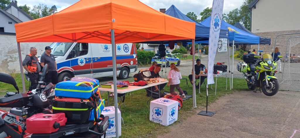Festyn Rodzinny Janowice Wielkie, na zdjęciu namiot wolontariatu pogotowia ratunkowego, motoambulans oraz karetka