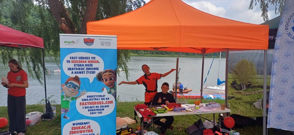 Piknik Edukacyjny - Przystań Żeglarska Izery, na zdjęciu namioty wolontariatu Pogotowia Ratunkowego w tle zbiornik wodny